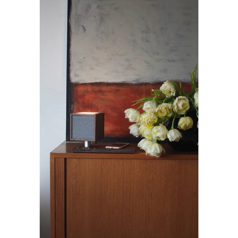 The Tivoli Audio Revive compact speaker delivers powerful sound while recharging your devices wirelessly. Walnut cabinet image